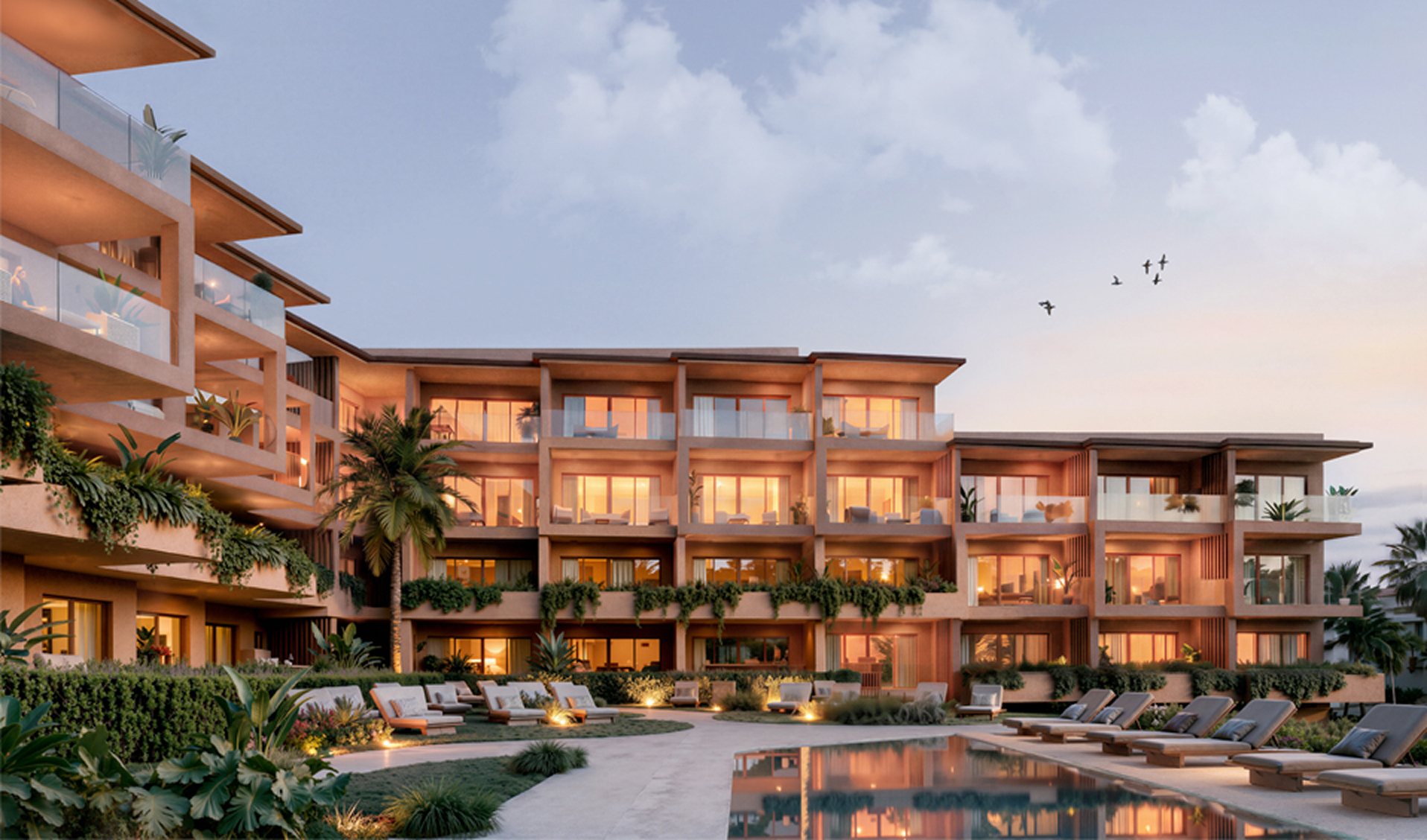 Fachada del complejo con la piscina al atardecer